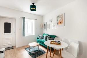 sala de estar con sofá verde y mesa en L'Ecrin Vert - 150m Restaurant 3 étoiles, en Vonnas