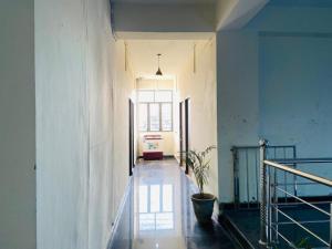 a hallway of a building with a potted plant at Abuzz Oxfordcaps Cedar Homes in Jhājra