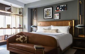 a bedroom with a bed and a leather couch at Thompson Dallas, by Hyatt in Dallas