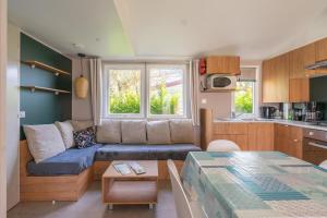 a living room with a couch and a table at Camping Les Charmettes in Les Mathes