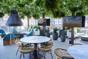 a patio with tables and chairs and a tv at Thompson Dallas, by Hyatt in Dallas