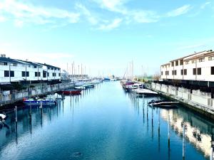 a river with boats docked next to some buildings at Marina Dream House in Lignano Sabbiadoro