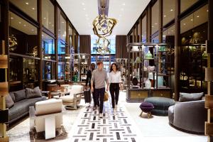 a man and a woman walking through a store lobby at Thompson Dallas, by Hyatt in Dallas