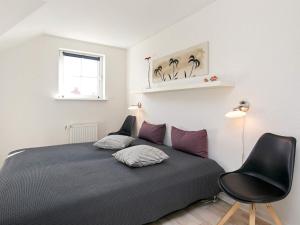 ボーゲンセにある8 person holiday home on a holiday park in Bogenseのベッドルーム1室(ベッド1台、椅子、窓付)