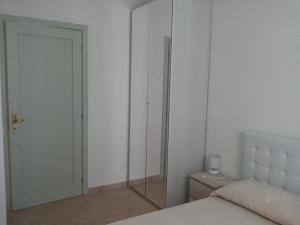a bedroom with a bed and a closet with a mirror at Appartamenti Isola Rossa in Valledoria