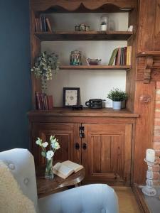 een kamer met een boekenplank met een tafel en een stoel bij Cosy 3-bedroom home with garden and log burner. in Bradford on Avon