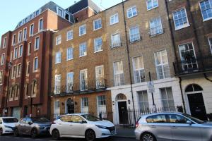 a group of cars parked in front of a brick building at Baker Street by Viridian Apartments in London