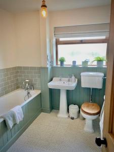 y baño con lavabo, aseo y bañera. en Cosy 3-bedroom home with garden and log burner., en Bradford on Avon