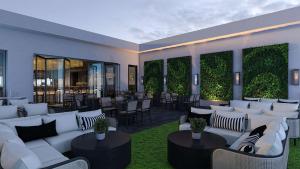 a living room with white couches and tables and chairs at Tempo By Hilton Raleigh Downtown in Raleigh