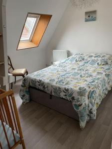 a bedroom with a bed with a comforter and a window at Appartement en centre ville pour 4 personnes in Roye