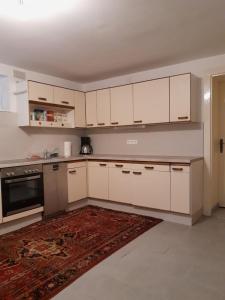 an empty kitchen with white cabinets and a rug at Ferienwohnung 2 Jöbstl 