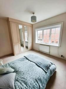 a bedroom with a bed and two windows at City Chester Entire House Central in Chester