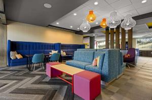 a lobby with a couch and a table and chairs at Tru By Hilton Christiansburg in Christiansburg
