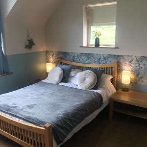 a bedroom with a bed with two pillows and a window at Wild Atlantic Stay Guest House Self-Catering in Galway