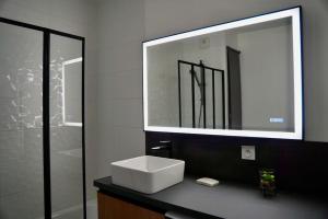un bagno con un lavandino bianco e uno specchio di "Haven" a Saint-Priest Altre 16 foto
