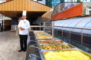 a chef standing in front of a buffet of food at CLUB BAYAR BEACH HOTEL in Alanya