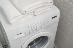 a washing machine with towels on top of it at APT Nadmorskie - Portowe in Kołobrzeg