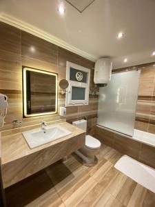 a bathroom with a sink and a toilet and a tv at Hotel exceptional luxury apartments next to Cairo airport at ocean blue compound Heliopolis in Cairo