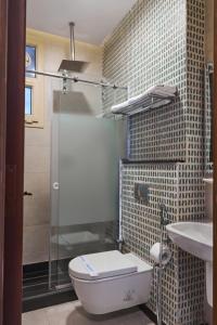 a bathroom with a shower and a toilet and a sink at El Mena Grand in ‘Izbat al Burj