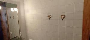 uma casa de banho com dois corações numa parede de azulejos em Ski apartment Sellette San Sicario Alto em San Sicario