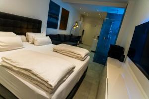 ein Hotelzimmer mit 2 Betten und einem Sofa in der Unterkunft White Lofty und White Studio in Düsseldorf