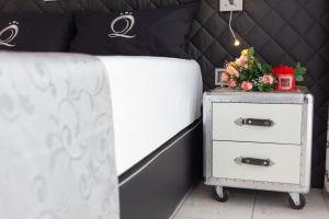 ein Schlafzimmer mit einem Bett und einem Nachttisch mit Blumen darauf in der Unterkunft VILLA ADRIANA-The Queen Apartments Luxury Living in Luxemburg (Stadt)