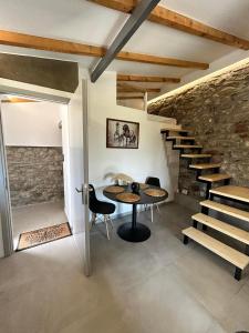 ein Zimmer mit einem Tisch, Stühlen und einer Treppe in der Unterkunft Ktimaoliva2 in Nafpaktos