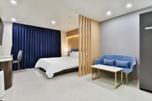 una camera d'albergo con letto e sedia blu di Hotel Palace Gyeongju a Gyeongju