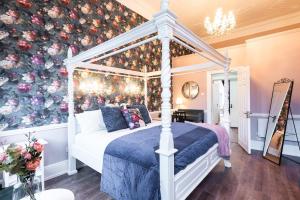 a bedroom with a canopy bed with a floral wall at 4 Poster Luxury Georgian Apartment in Dublin