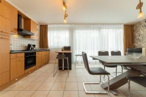 a kitchen with a table and chairs in a room at VILLA ADRIANA-The Queen Apartments Luxury Living in Luxembourg