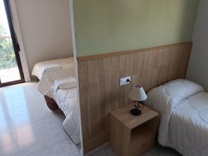 Habitación con 2 camas y una lámpara en una mesa. en Hotel La Galera del Mar - Altea, en Altea