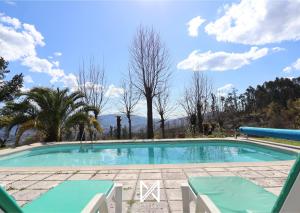 - une grande piscine avec 2 chaises longues devant dans l'établissement MyStay - Casa da Carvalha, à Arcos de Valdevez