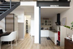 a kitchen and living room with white cabinets and a staircase at AMBROSIA HOME, moderno Loft tra Navigli e Bocconi - Daniele Case Vacanza in Milan +18 photos