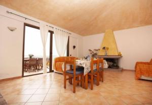 a living room with a table and chairs and a couch at Bella Vista 3 in Lu Lioni +6 photos