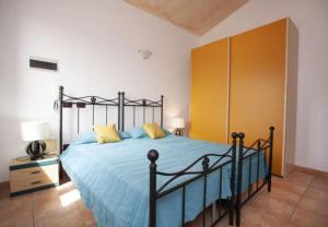 a bedroom with a bed with blue sheets and yellow pillows at Bella Vista 3 in Lu Lioni