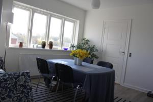 a dining room with a table and chairs and windows at Bed and Breakfast i Gelsted in Gelsted