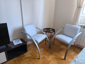 een woonkamer met 2 stoelen en een tafel bij Apartman Quality in Voždivac