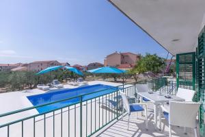 a balcony with a pool and a table and chairs at NEW! Apartments with shared pool, Vodice in Vodice