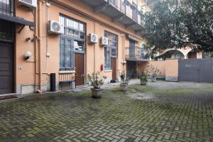 a courtyard with potted plants in front of a building at Moderno e Confortevole Loft tra Navigli e Bocconi in Milan