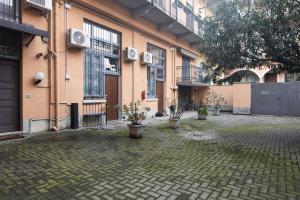 a courtyard with potted plants in front of a building at AMBROSIA HOME, moderno Loft tra Navigli e Bocconi - Daniele Case Vacanza in Milan
