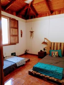 1 dormitorio con 2 camas en una habitación con techos de madera en Casa Qi Boho B&B en Cabuya
