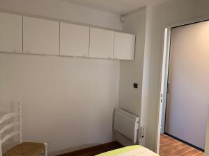 een witte kamer met een bed en witte kasten bij Appartement Domaine de la Coudouliere + piscine (mai à octobre) in Six-Fours-les-Plages