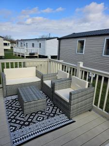 eine Terrasse mit Stühlen und Tischen auf einer Terrasse in der Unterkunft Lovely 3 Bed Caravan near to beach 5 star Reviews in Cleethorpes