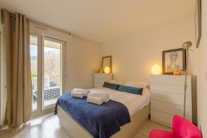 a bedroom with a large bed and a balcony at Les Terrasses Montfleury, aux portes d'Annecy- Une exclusivité LLA Selections by Location lac Annecy in Annecy