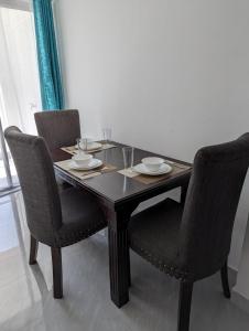 a dining room table with two chairs and a wooden table with glasses at Hosted by Pauline in Nairobi