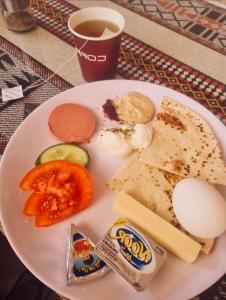 a plate of food with eggs bread and vegetables at Rum Goldeneye luxury camp in Wadi Rum