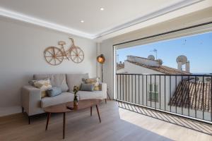 a living room with a couch and a bike on the wall at Apartamento con vistas en Puerto Banús in Marbella