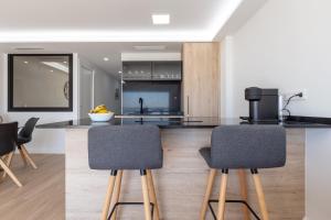a kitchen with a counter with two bar stools at Apartamento con vistas en Puerto Banús in Marbella