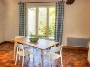 a dining room with a wooden table and white chairs at Gîte Ferme Traditionnelle Près de la Forêt, Animaux Admis - FR-1-381-68 in Cheillé