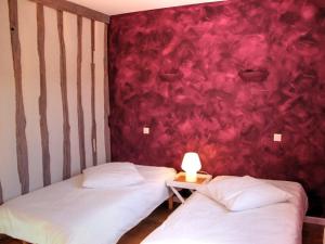 2 Betten in einem Zimmer mit roter Wand in der Unterkunft Gîte Cheillé, 3 pièces, 4 personnes - FR-1-381-68 in Cheillé